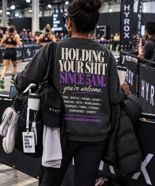 Holding Your Shit Since 5AM asphalt crewneck worn by race-day support crew at an athletic event