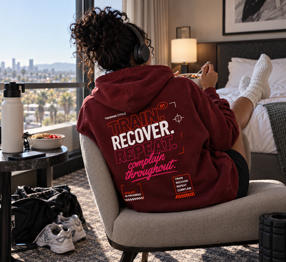 Race Scoop maroon Train Recover Repeat hoodie worn during a post-workout recovery moment, featuring bold back graphic artwork and relaxed athlete lifestyle styling.