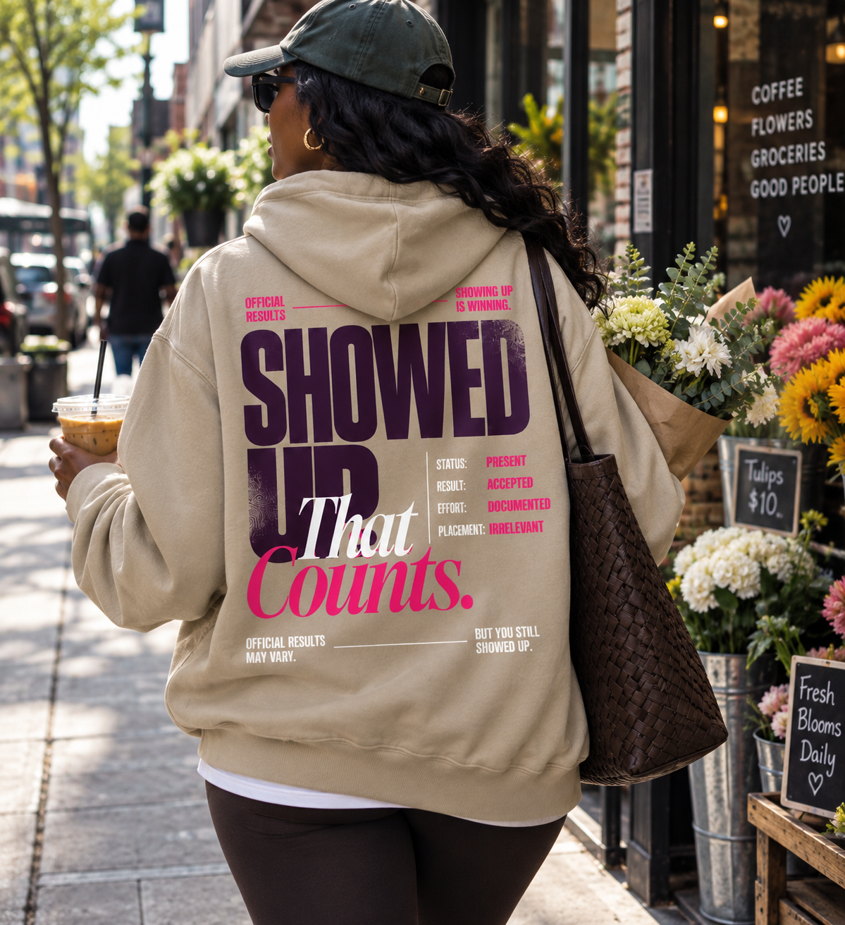 Race Scoop Showed Up That Counts khaki hoodie worn in an everyday city setting, featuring statement back artwork celebrating effort, presence and showing up regardless of results.